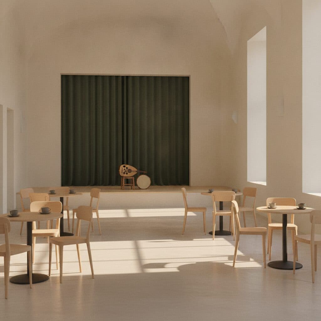 Heller Foyersaal mit runden Tischen, Stühlen und einer niedrigen Bühne, auf der eine Laute und eine Handtrommel liegen.