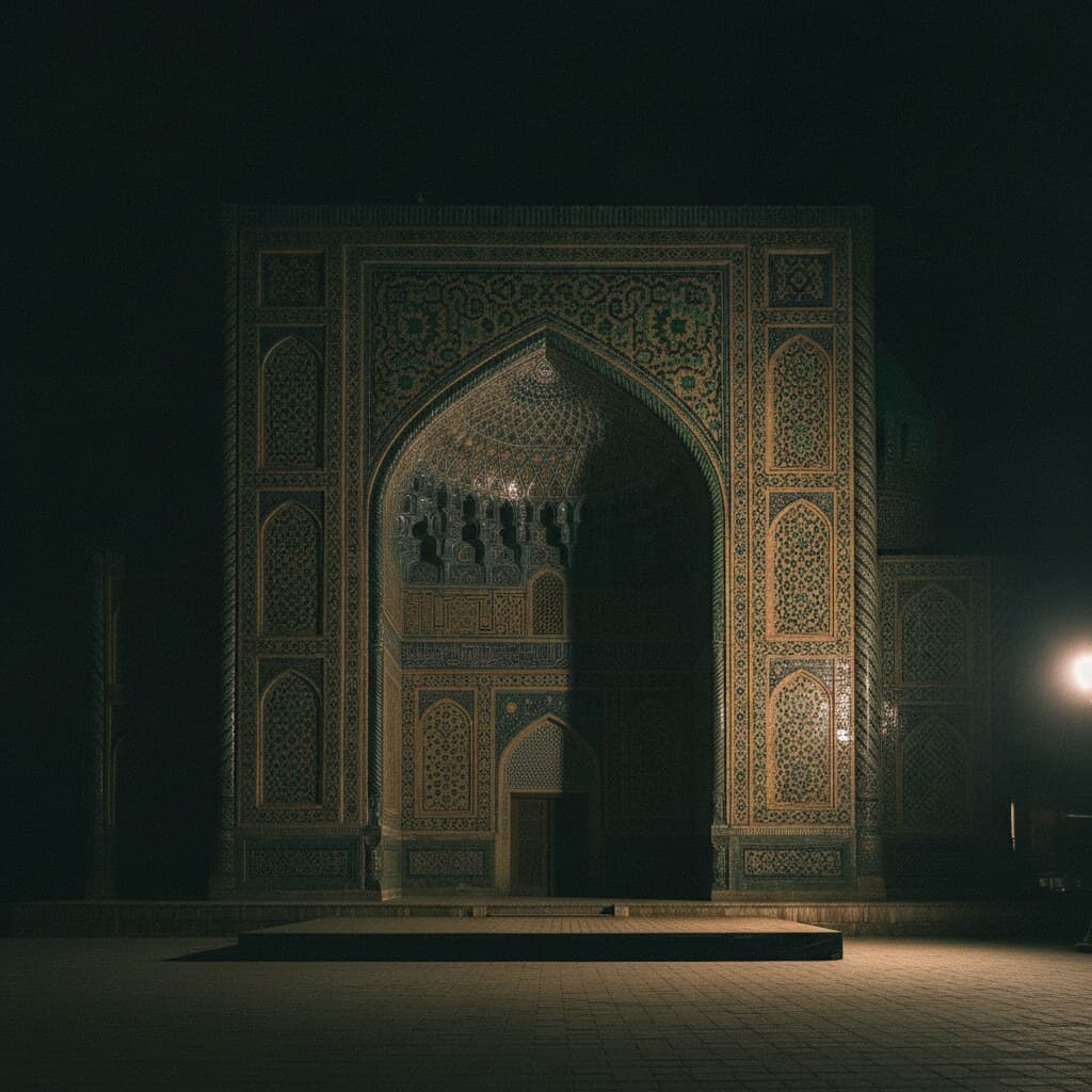 Richly tiled portal of a Central Asian madrasa at night, an empty low stage platform in front of it.